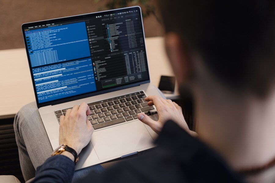 Developer coding a business system on a laptop